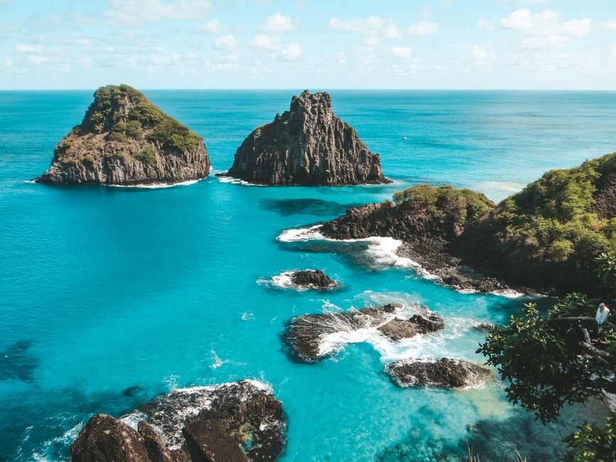 A breathtaking aerial view of the rocky coastline and blue waters of Fernando de Noronha, Brazil.